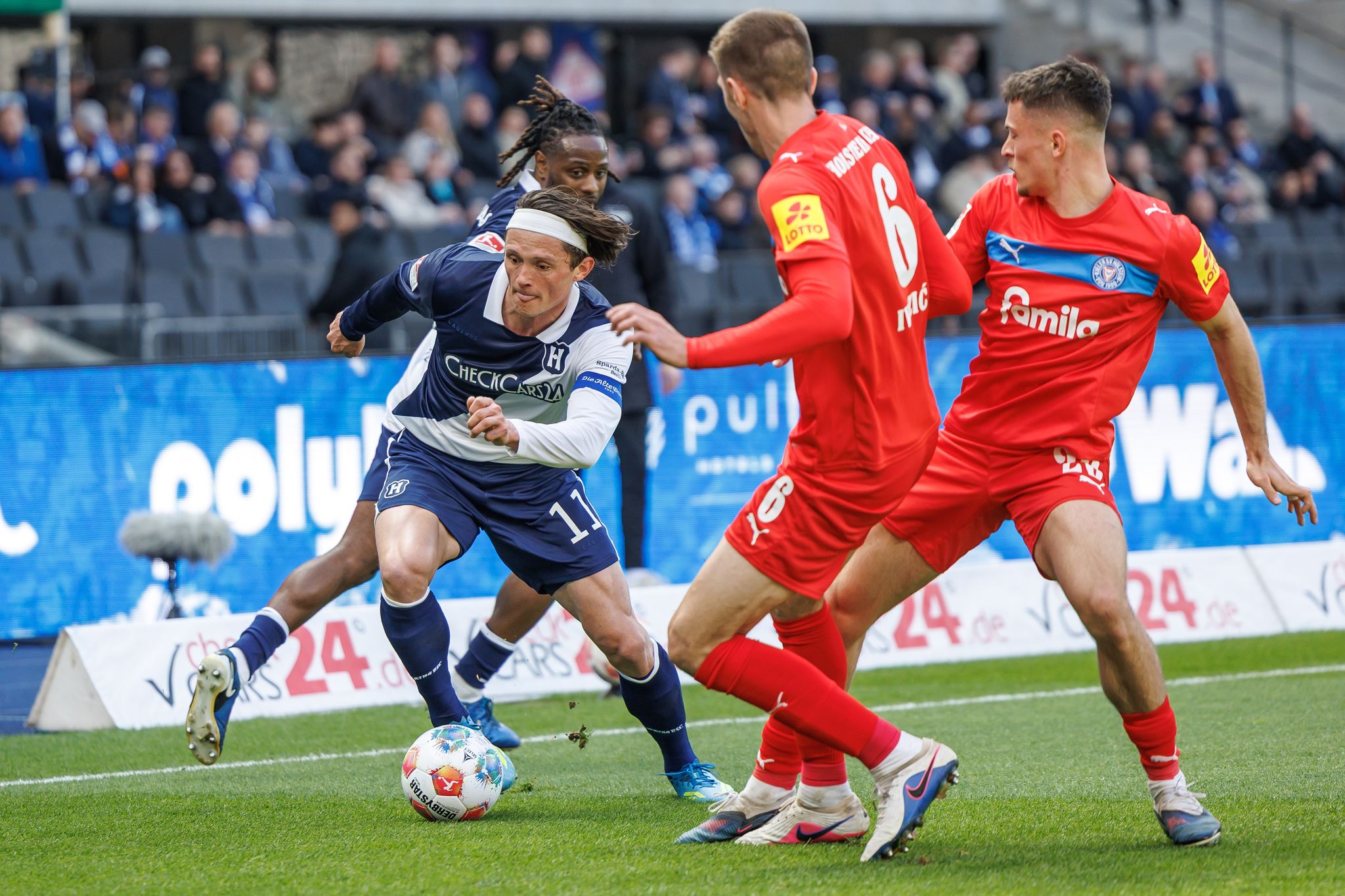Herthas Fabian Reese (l.) zieht an zwei Kieler Gegenspielern vorbei.