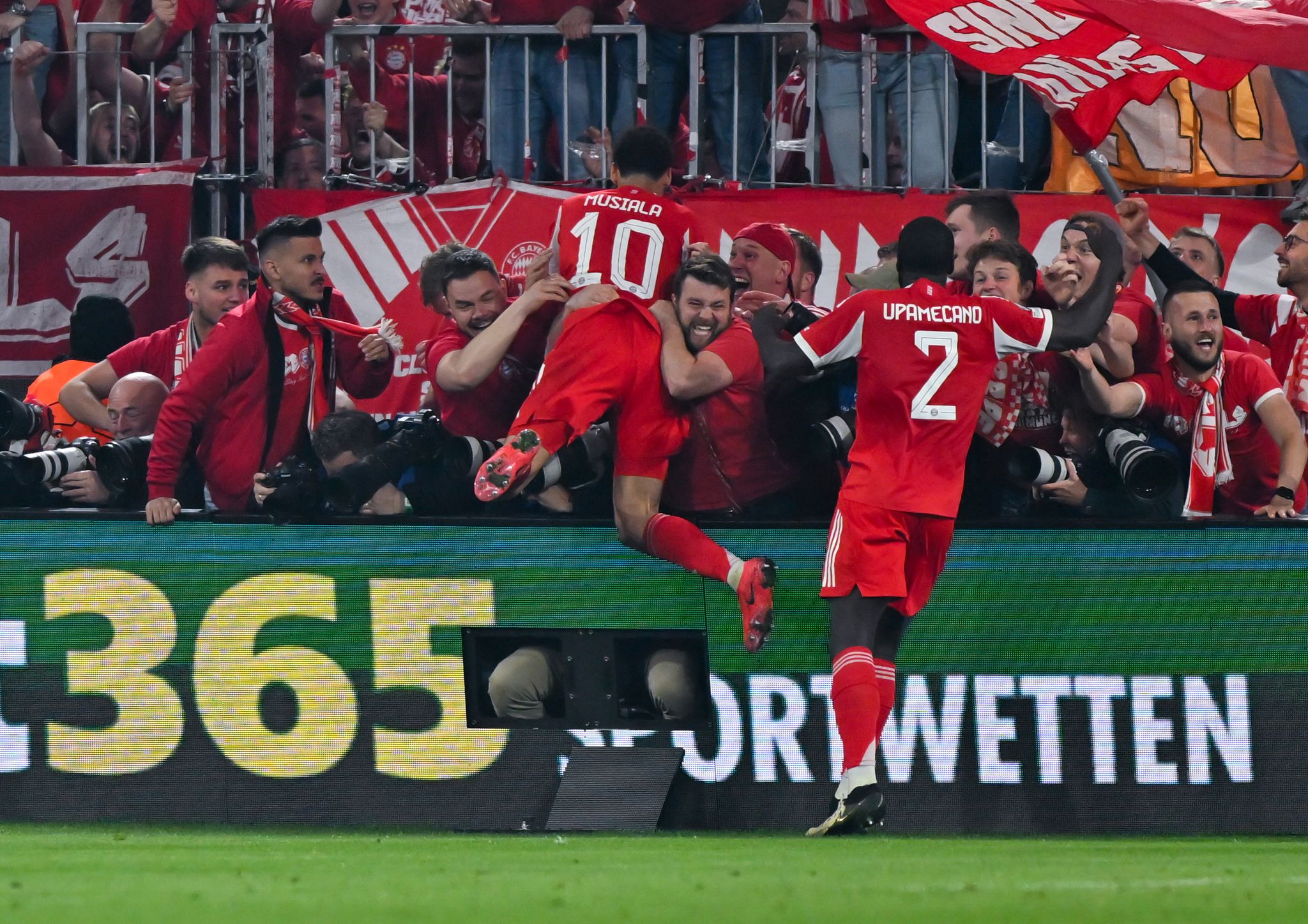 Nach dem letzten Bayern-Tor gegen Real springen einige Münchner Fans und Bayern-Profi Jamal Musiala im Jubel den anwesenden Fotografen in den Rücken.