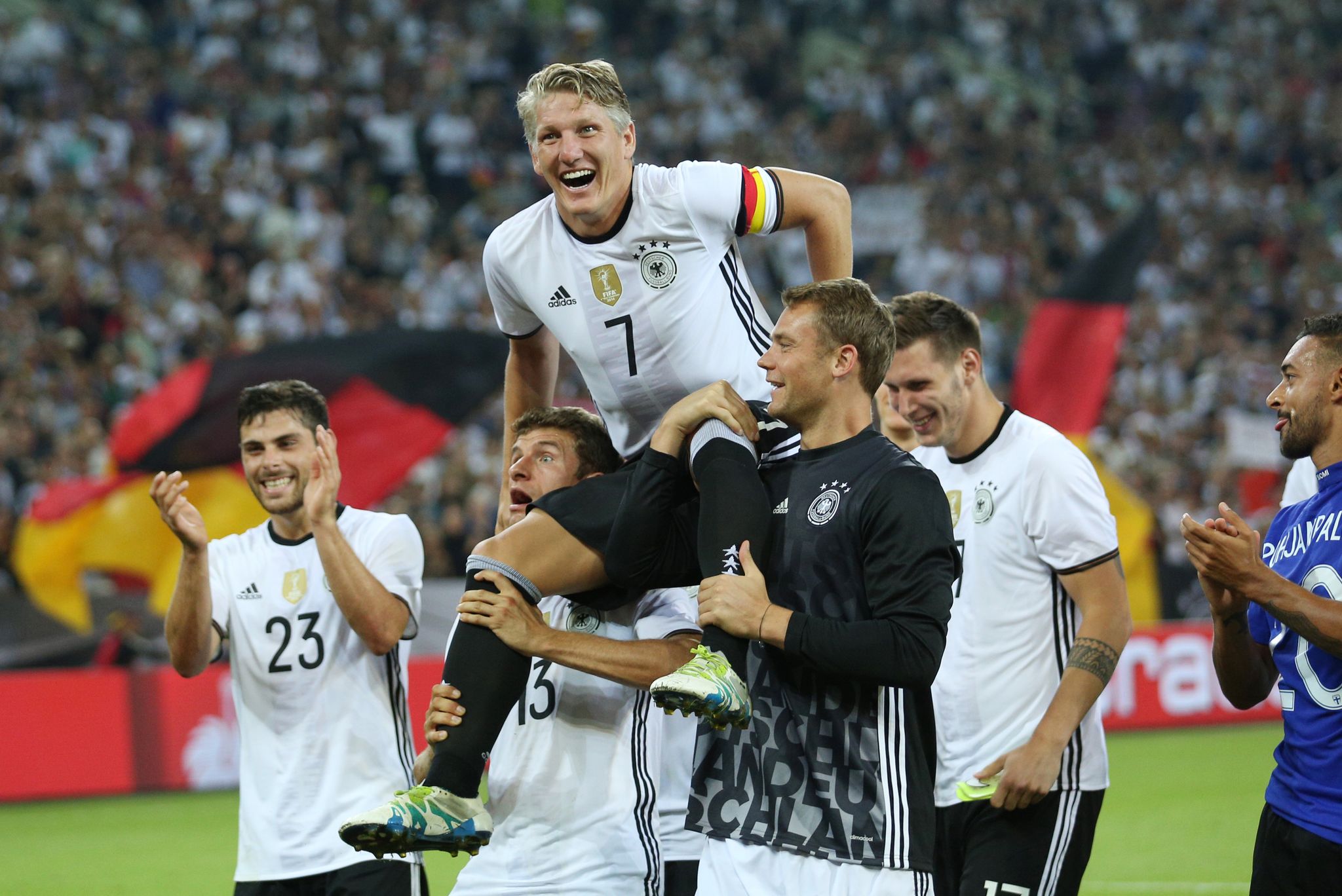 Bastian Schweinsteiger wird nach seinem letzten Länderspiel gegen Finnland von Thomas Müller (l) und Manuel Neuer (r) auf Schultern getragen. (Archivbild)