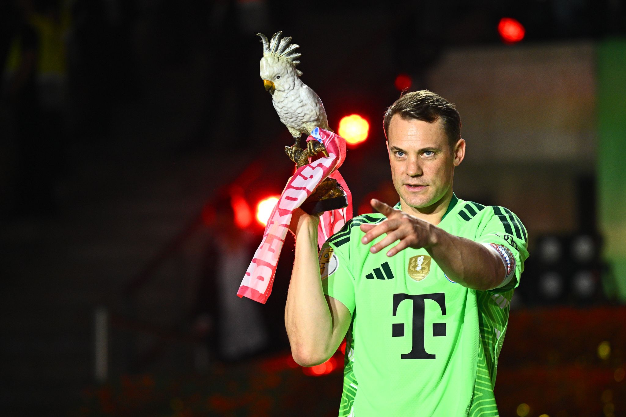 Manuel Neuer trägt nach dem Pokalsieg die Kakadu-Trophäe des FC Bayern.