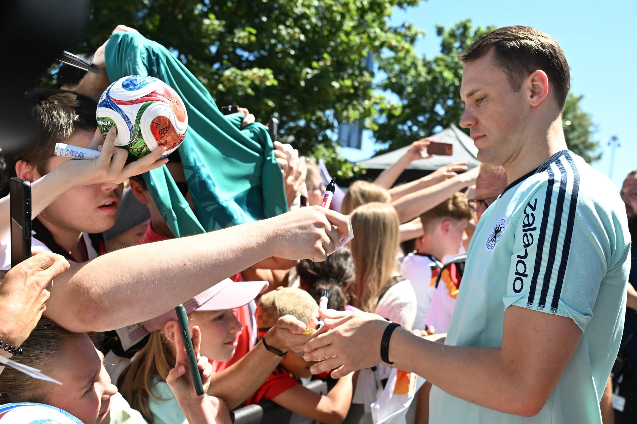 Manuel Neuer schreibt Autogramme für die DFB-Fans.