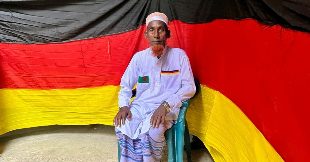 Der 77-jährige bangladeschische Bauer Amjad Hossain posiert mit einer deutschen Fahne