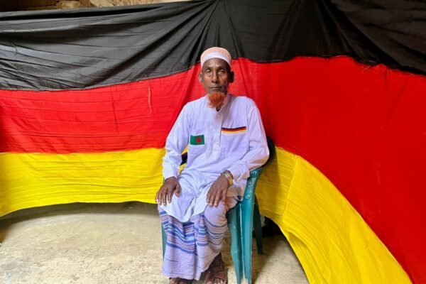 Der 77-jährige bangladeschische Bauer Amjad Hossain posiert mit einer deutschen Fahne