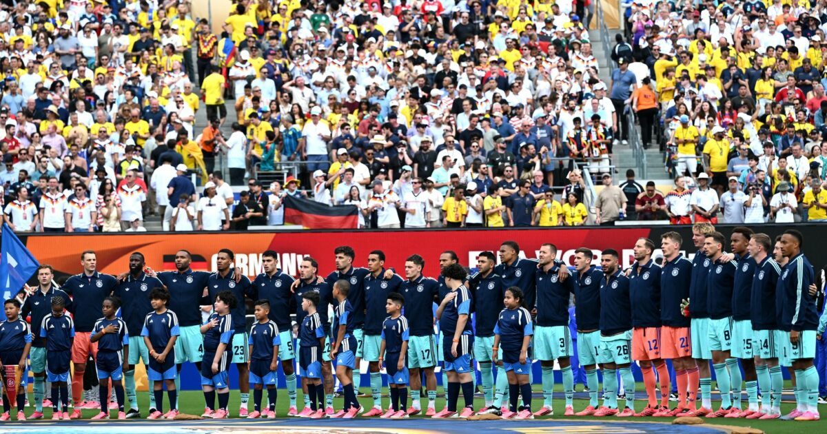 Die Fußball-Nationalmannschaft steht beim Abspielen der Nationalhymne am Mittelkreis.