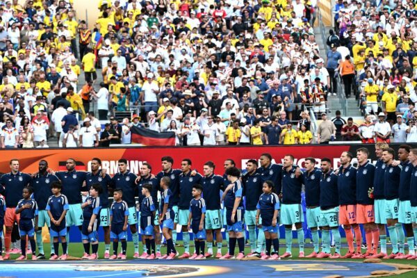 Die Fußball-Nationalmannschaft steht beim Abspielen der Nationalhymne am Mittelkreis.