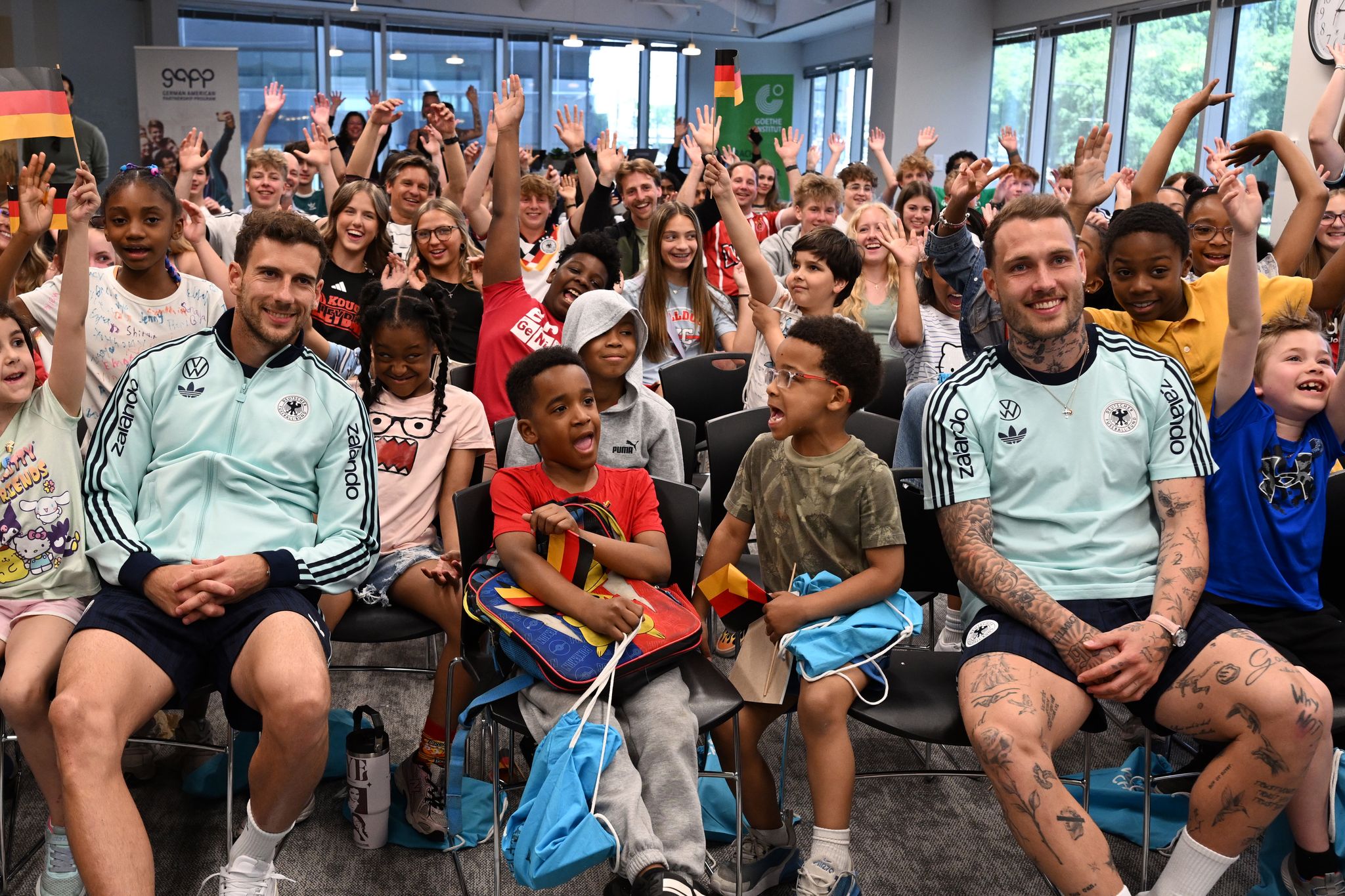 Leon Goretzka (l.) und David Raum (r.) beantworten Fragen von Kindern im Goethe-Institut in Chicago.