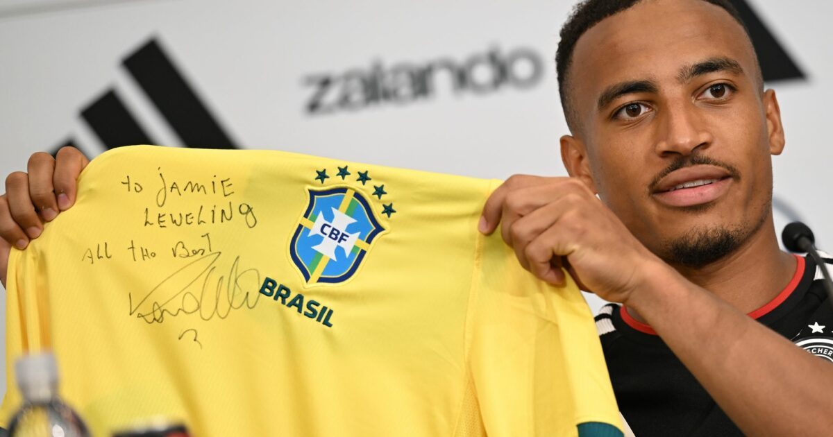 Jamie Leweling zeigt das Brasilien-Trikot mit der Unterschrift von Ronaldo.