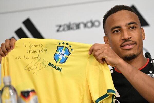 Jamie Leweling zeigt das Brasilien-Trikot mit der Unterschrift von Ronaldo.
