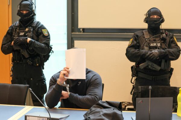Der Angeklagte sitzt im Gerichtssaal des Landgerichts Magdeburg zwischen zwei Justizbeamten.