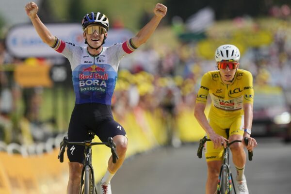 Remco Evenepoel jubelt im Ziel vor Tadej Pogacar.