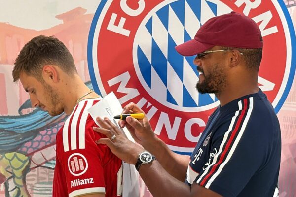 Trainer Vincent Kompany (r) malt - und Josip Stanisic muss raten.