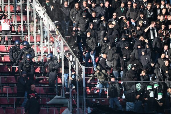 Anhänger von Borussia Mönchengladbach treten eine Schutzscheibe ein.